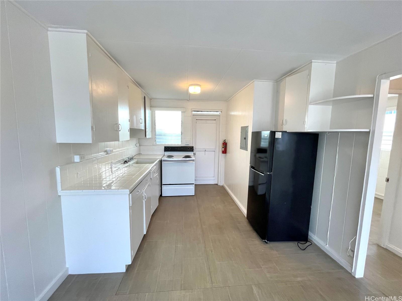 a large kitchen with a refrigerator and a sink