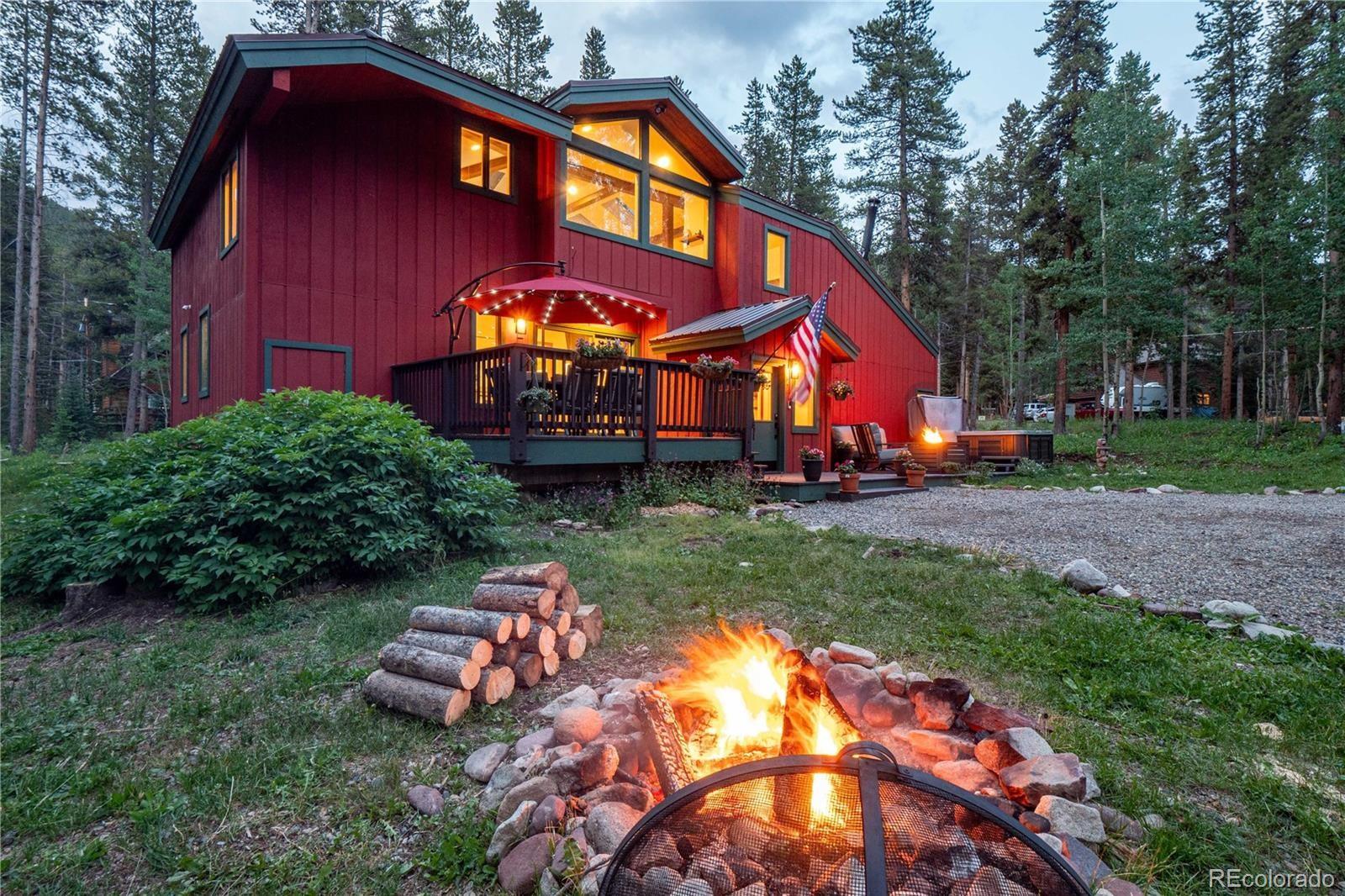 a view of a house with a yard fire pit and outdoor seating