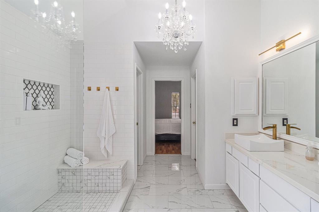 a spacious bathroom with a granite countertop sink a mirror and a shower