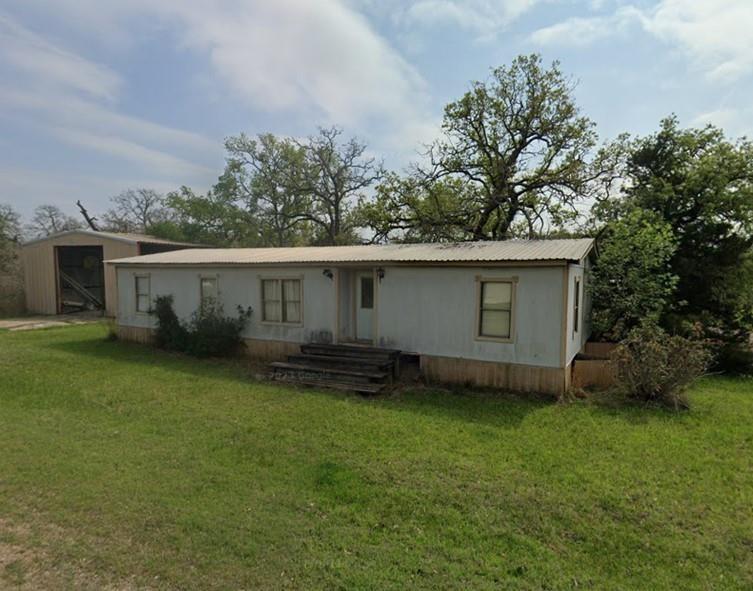 an outdoor view of house with backyard space and garden