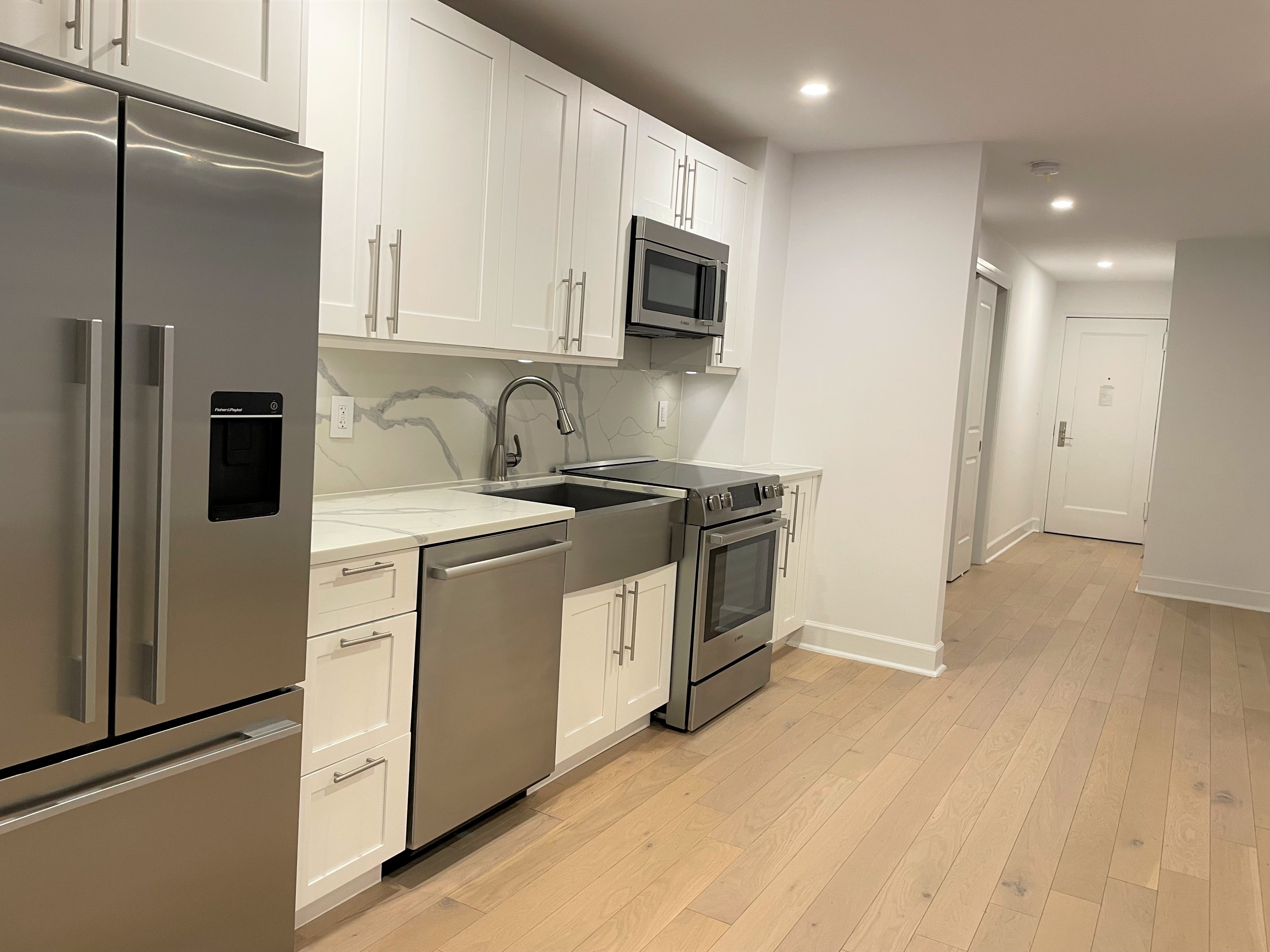 a kitchen with stainless steel appliances a refrigerator sink and microwave