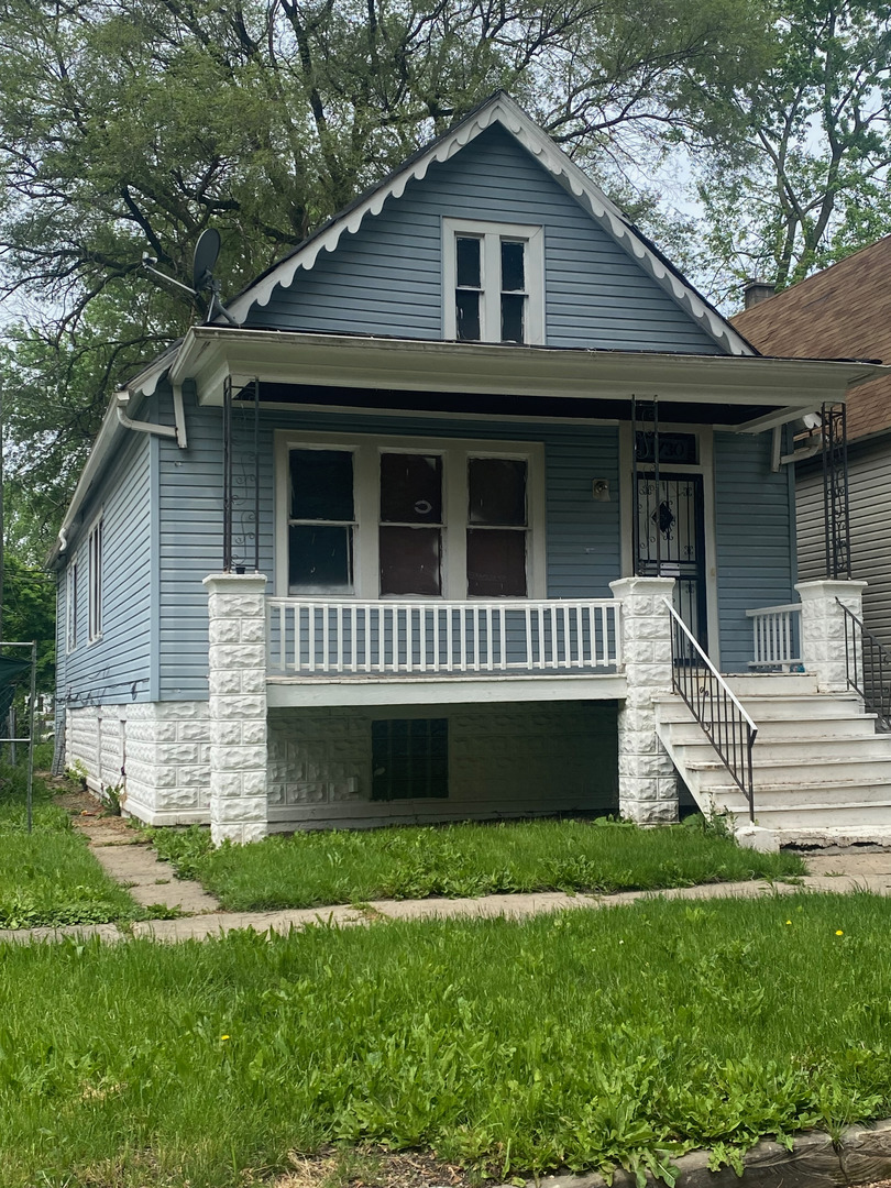 a front view of a house with a yard and potted plants