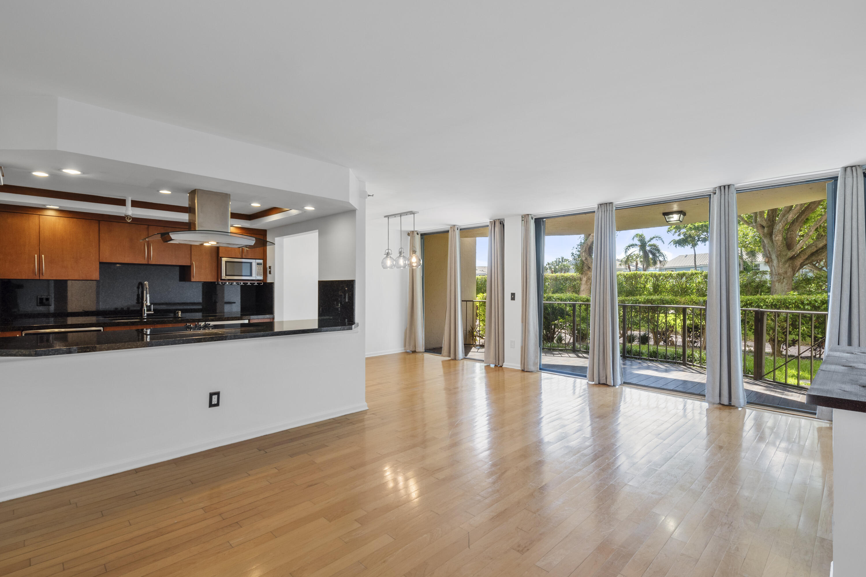 a view of a living room a large window and kitchen view