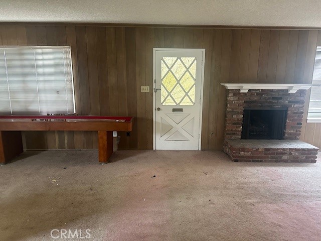 an empty room with windows and fireplace