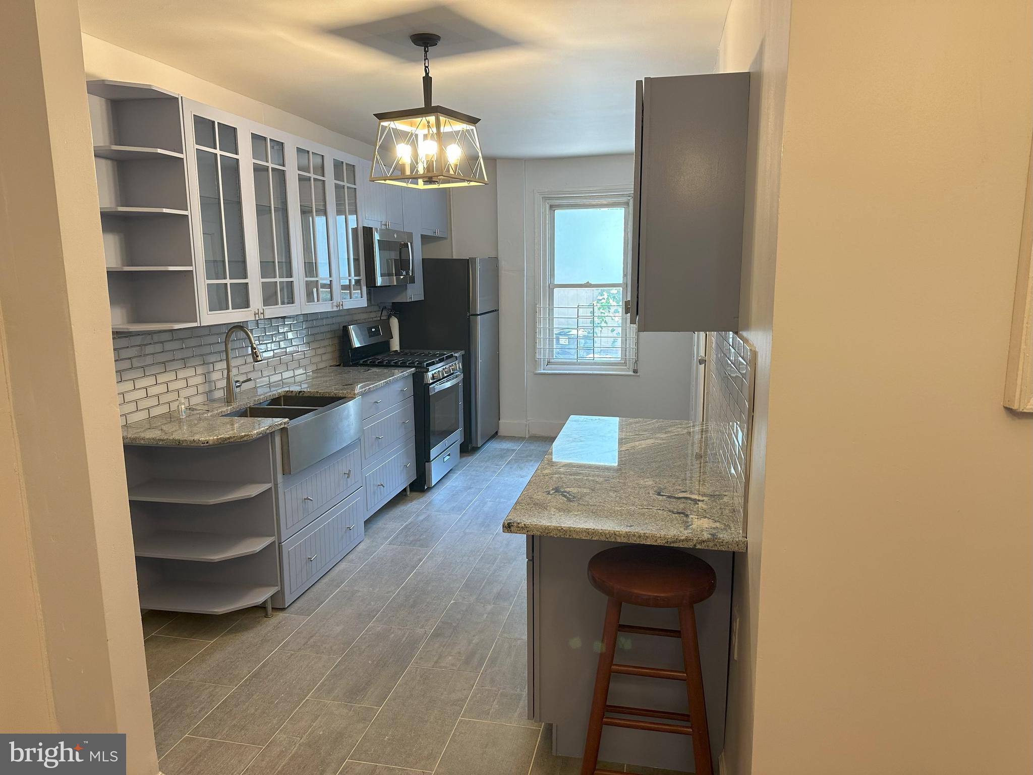 a kitchen with granite countertop a sink stove and cabinets