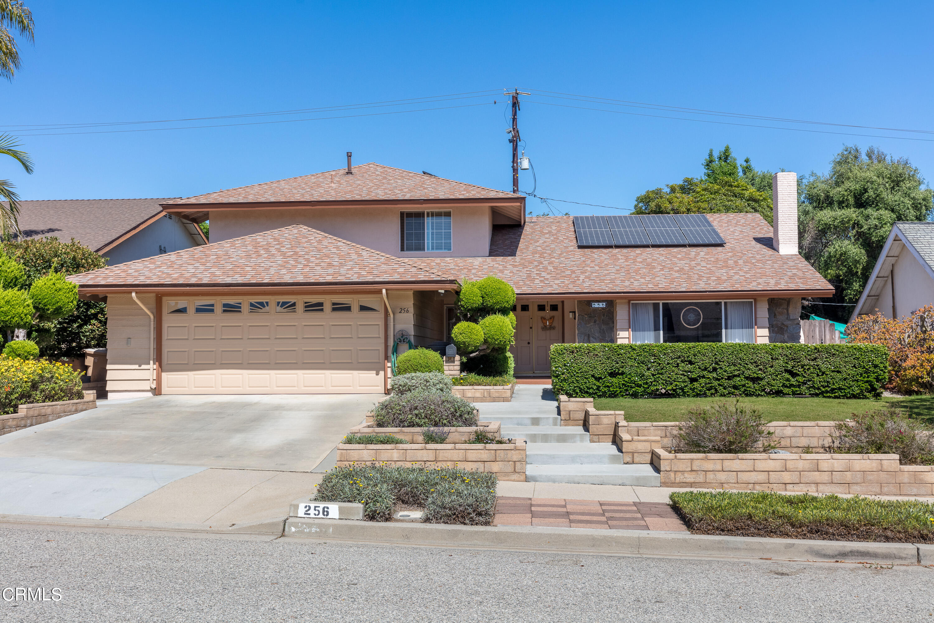 a front view of a house with a yard and potted plants