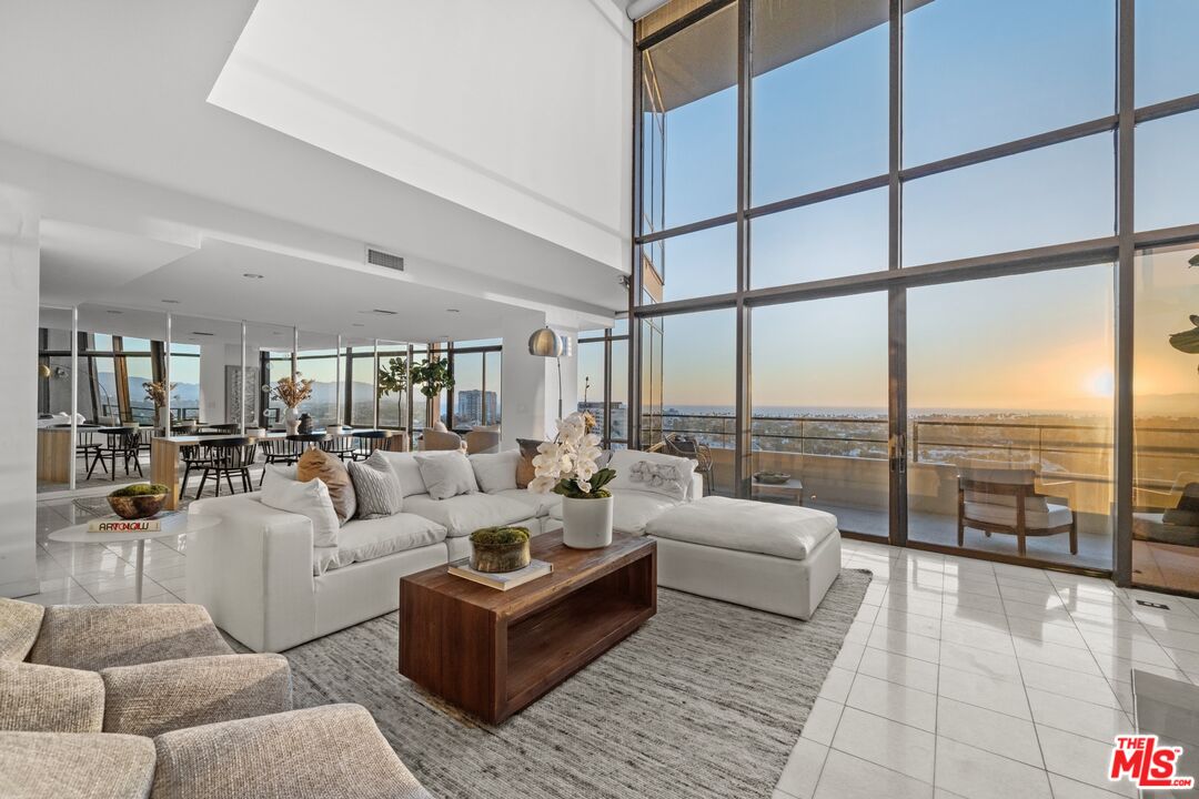 a living room with furniture and a floor to ceiling window