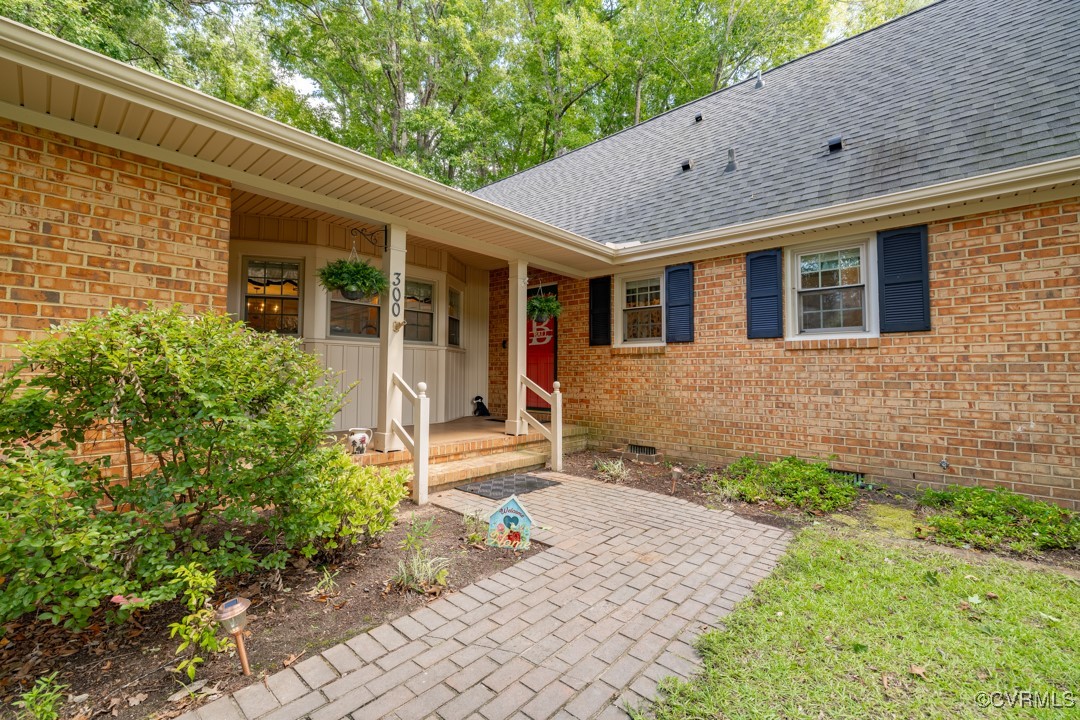 View of exterior entry with a covered porch