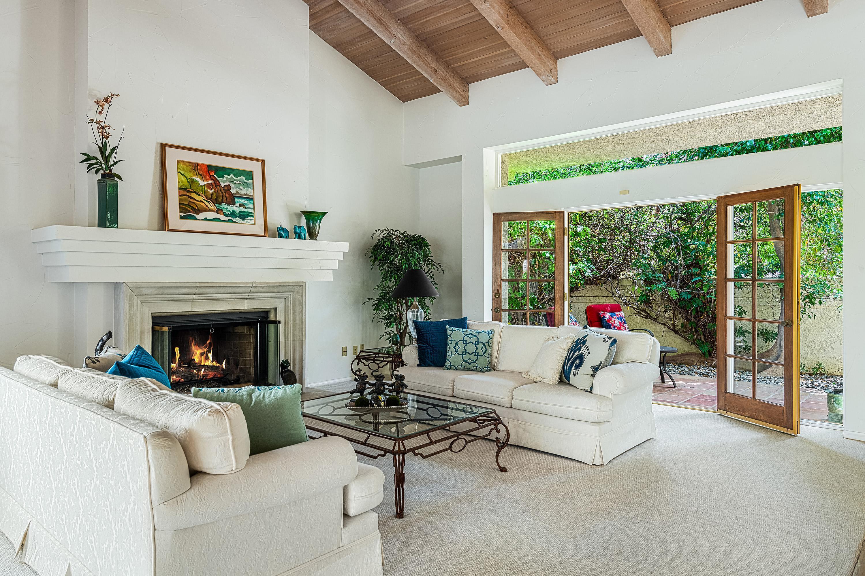 a living room with furniture a floor to ceiling window and a fireplace