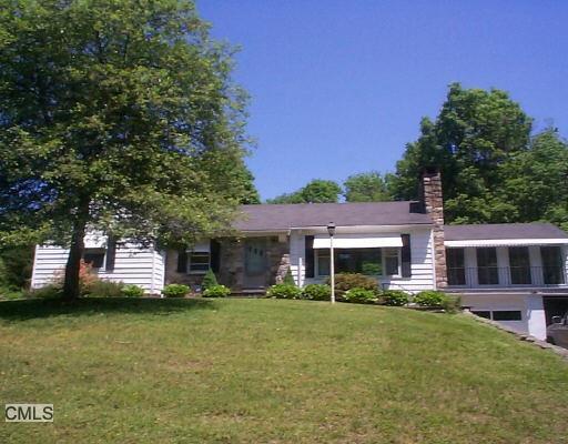 a front view of a house with a garden and trees