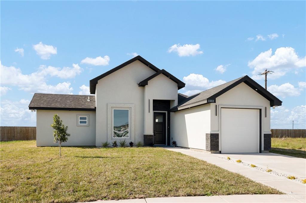 View of front of home featuring a garage and a front lawn