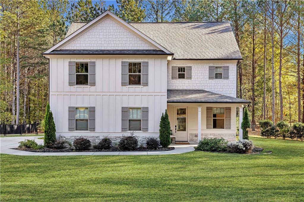 a house that is sitting in a big yard with large trees