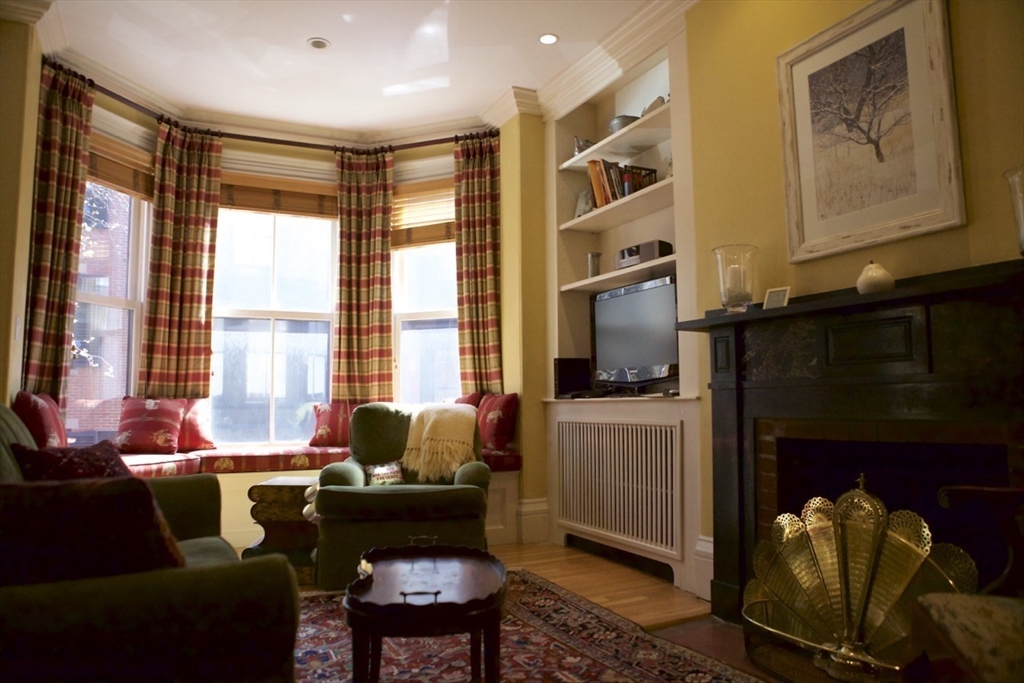 a living room with furniture a large window and a fireplace