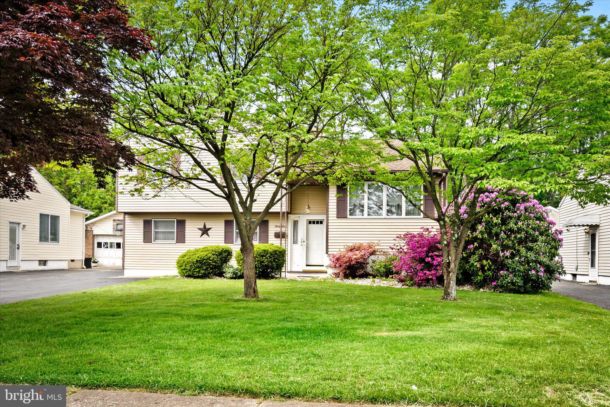 a front view of house with yard and green space