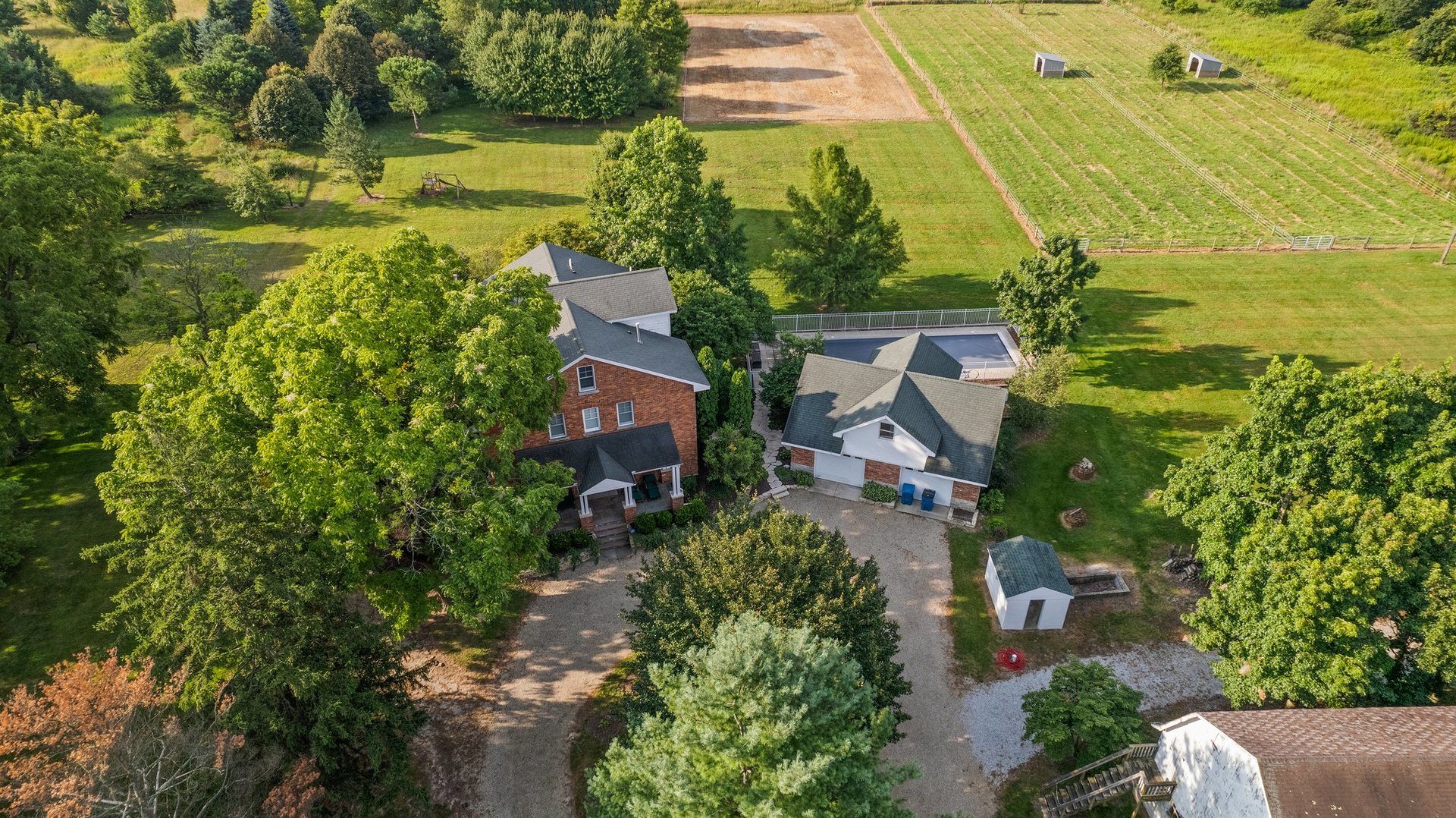 an aerial view of residential houses with outdoor space and trees all around