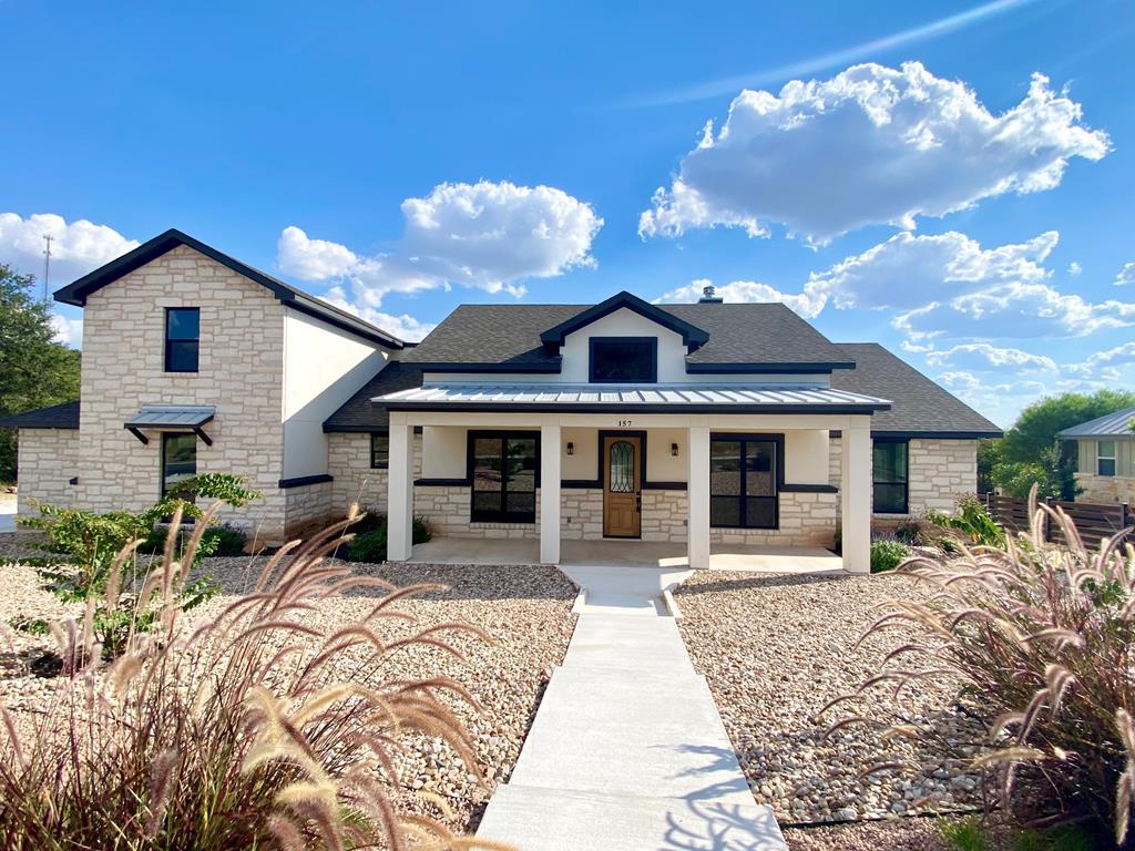 a front view of a house with a yard outdoor seating and garage