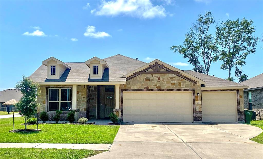 a front view of a house with a yard and garage