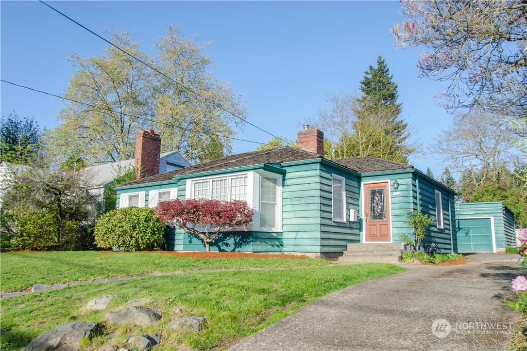 a front view of a house with a yard and potted plants