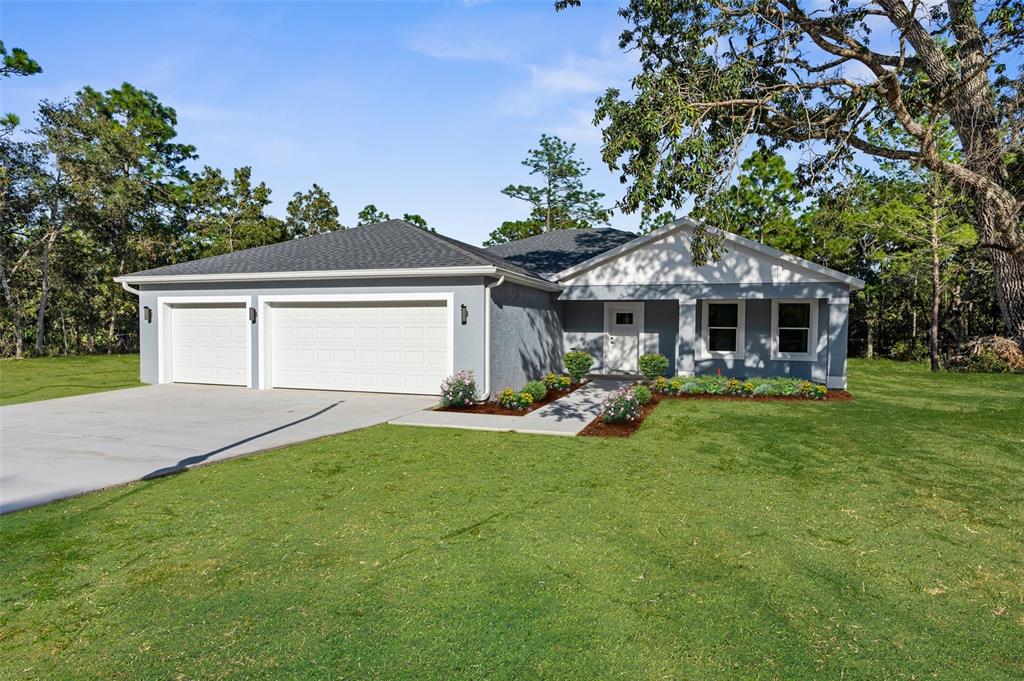 a front view of a house with a garden and trees