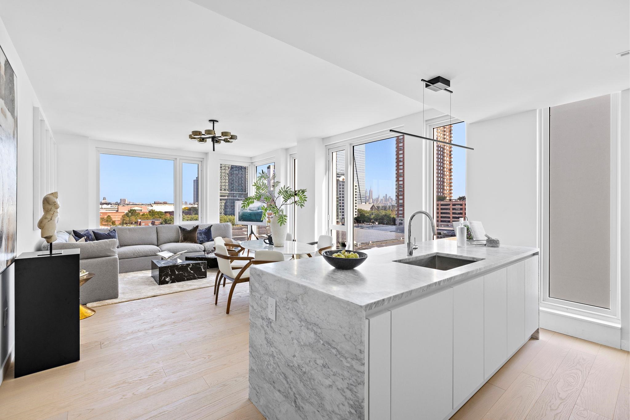 a living room with furniture kitchen view and large windows