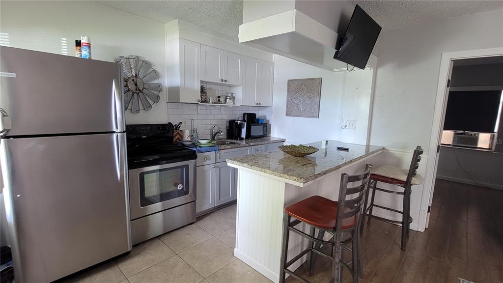 a kitchen with stainless steel appliances a refrigerator stove microwave and white cabinets