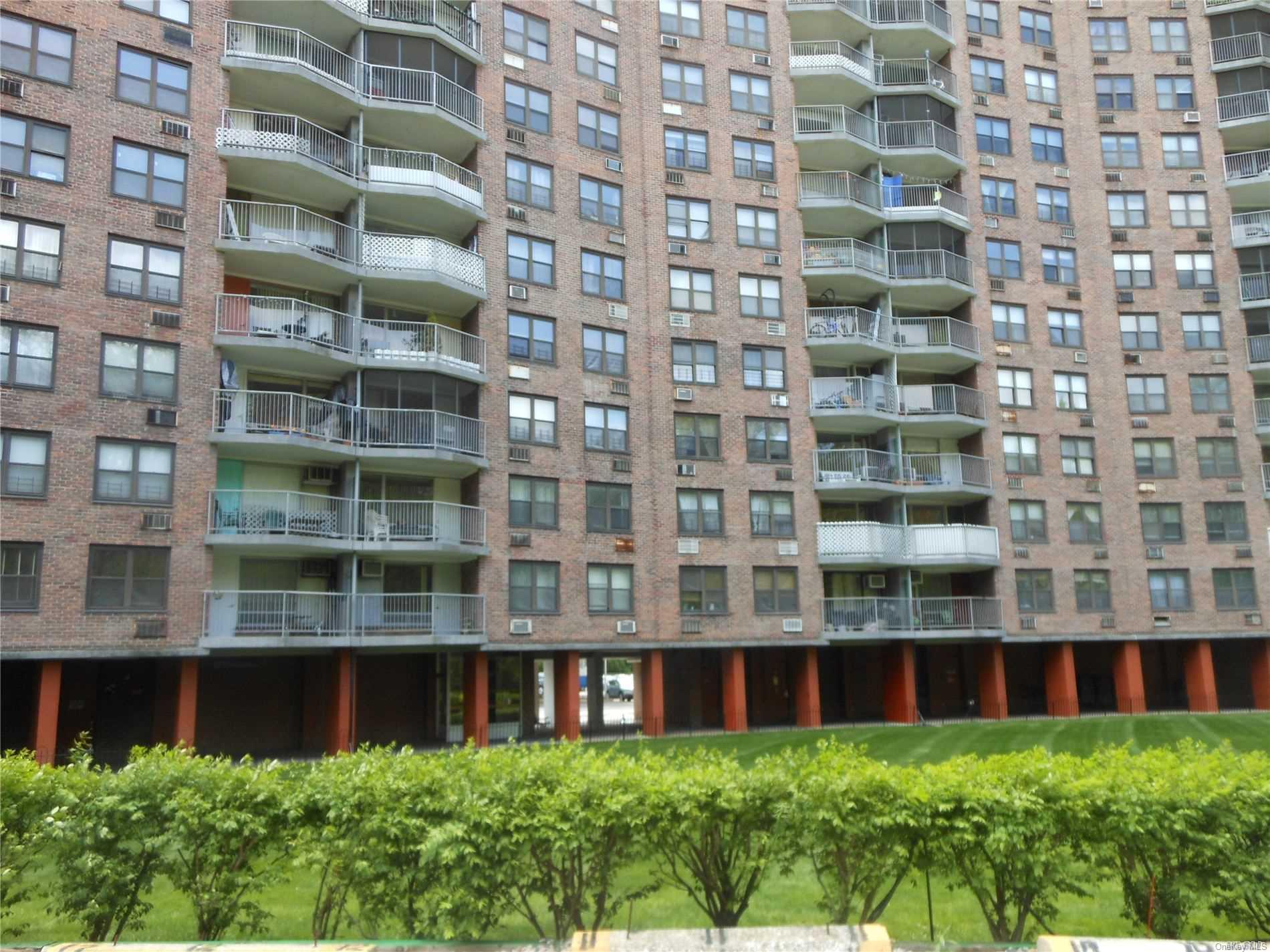 a view of front of brick building with a yard