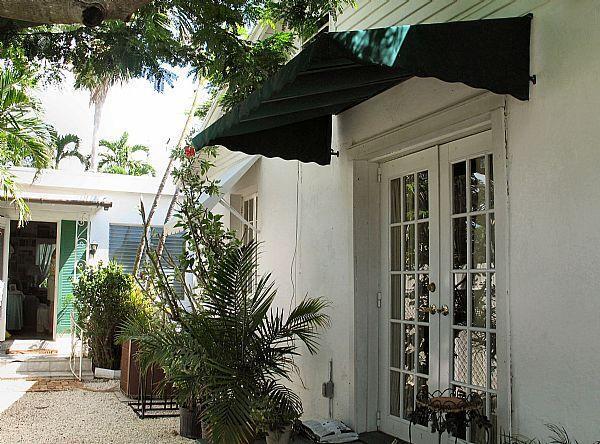 a view of a house with a potted plant ana a small yard