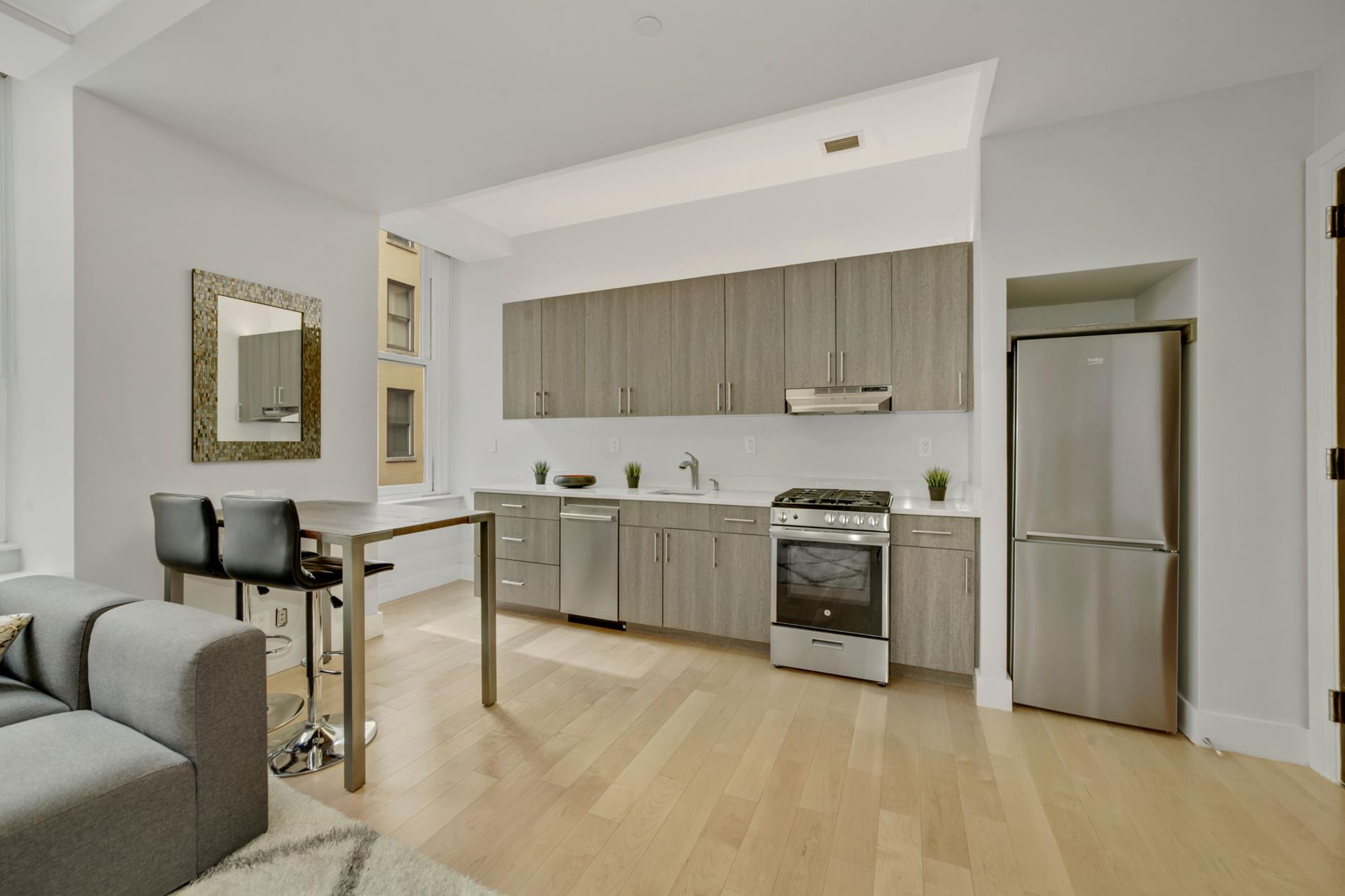 a kitchen with a refrigerator and a stove top oven