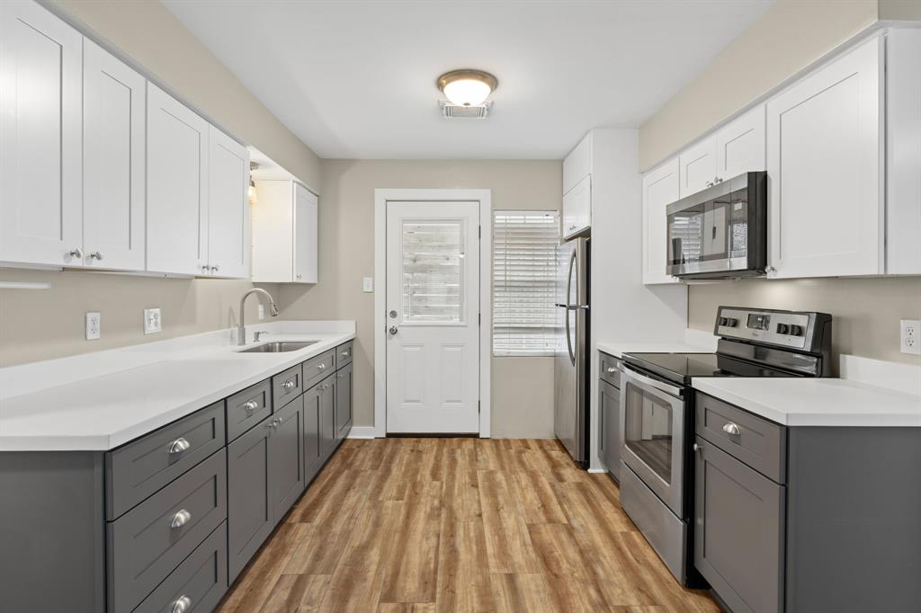 a kitchen with a sink stove top oven and cabinets