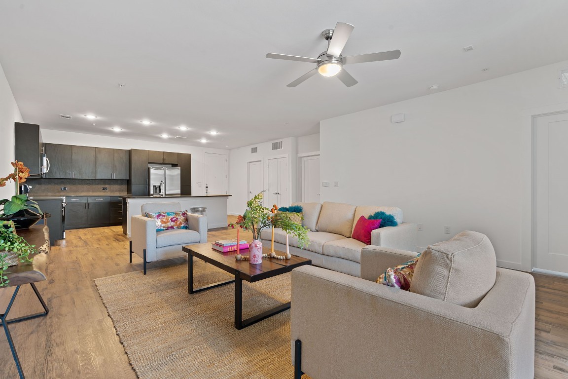 a living room with furniture kitchen view and a chandelier