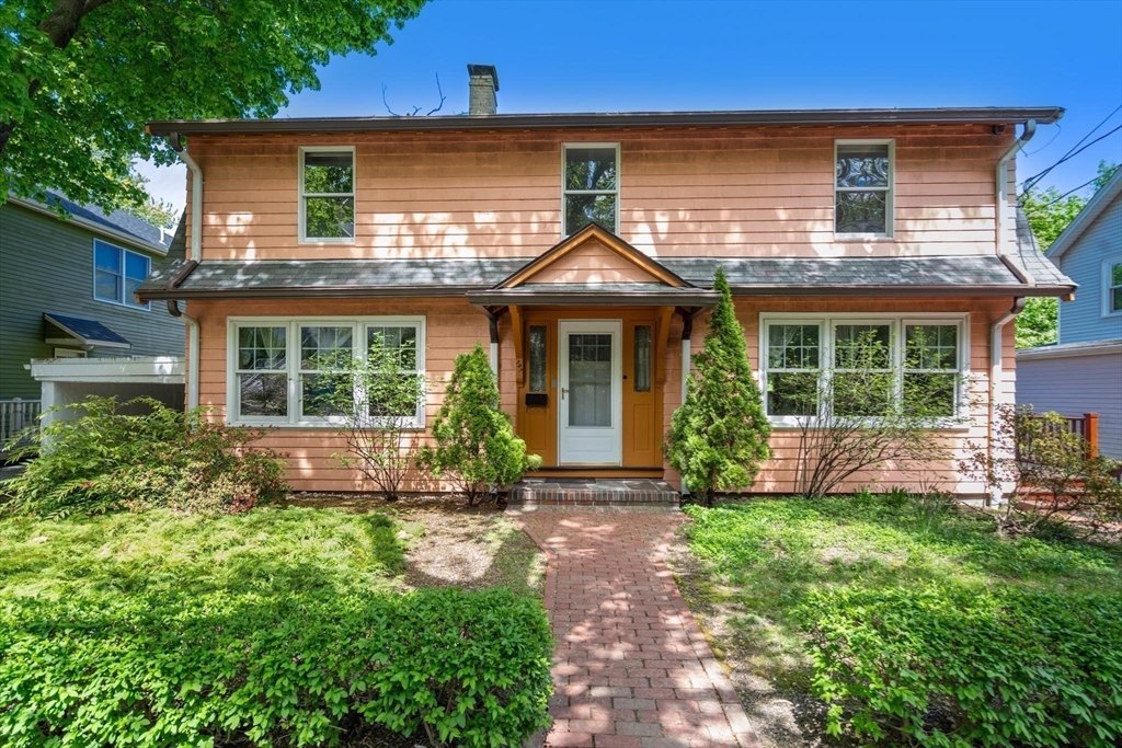 a front view of a house with a yard and outdoor seating