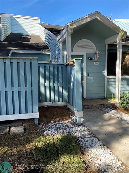 a view of a small house with wooden fence