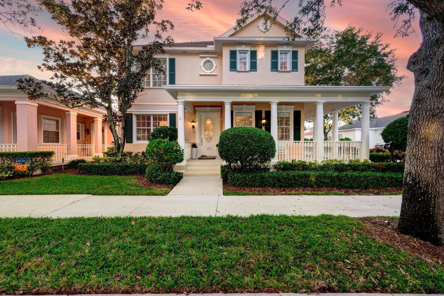 a front view of a house with a yard and potted plants