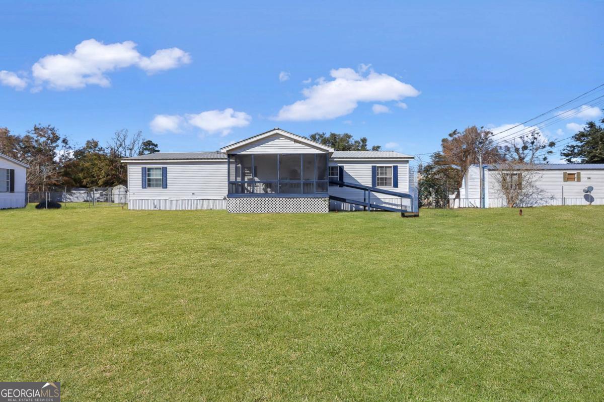 a view of a house with a big yard and large trees