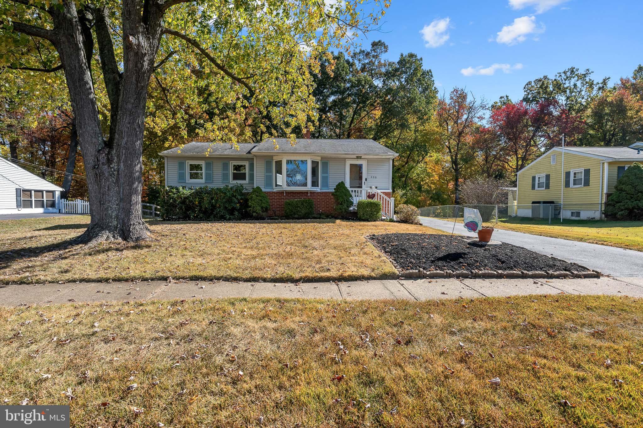 a front view of a house with a yard and trees