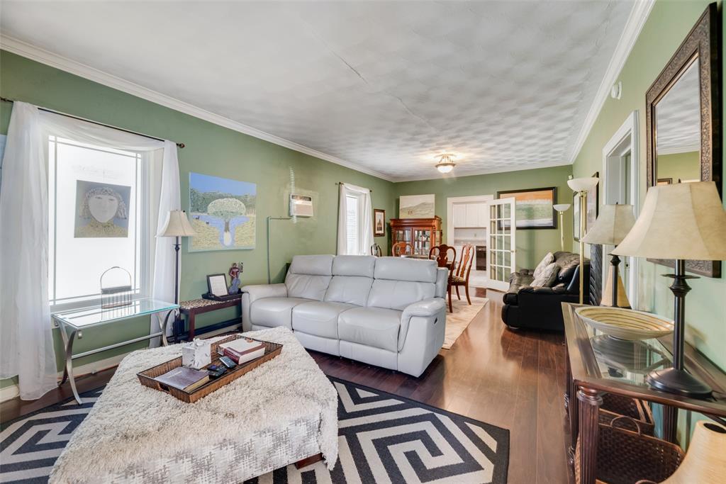 Living room with crown molding, dark hardwood / wood-style flooring, and a wealth of natural light