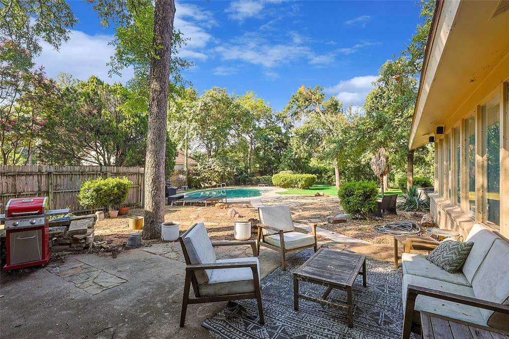 a view of backyard with outdoor seating and trees