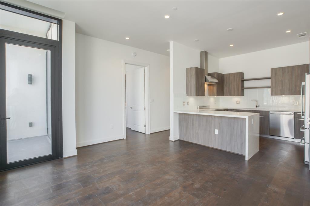 a view of a kitchen with a sink and dishwasher a refrigerator with wooden floor