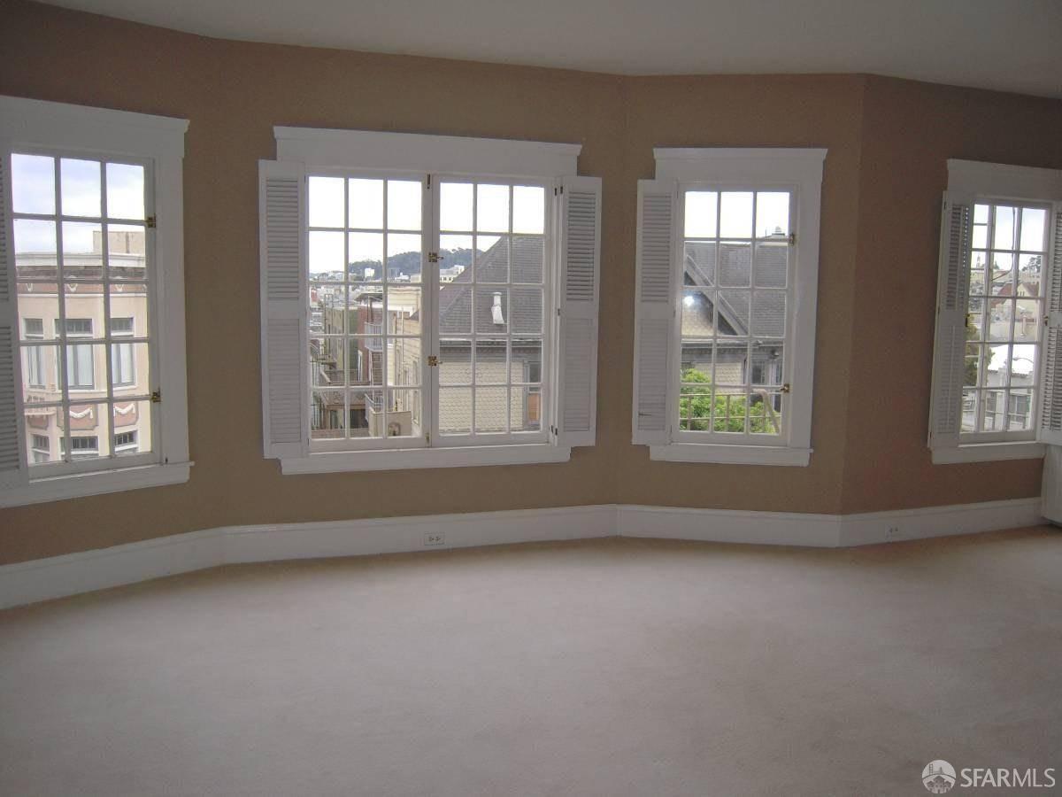 an empty room with windows and closet