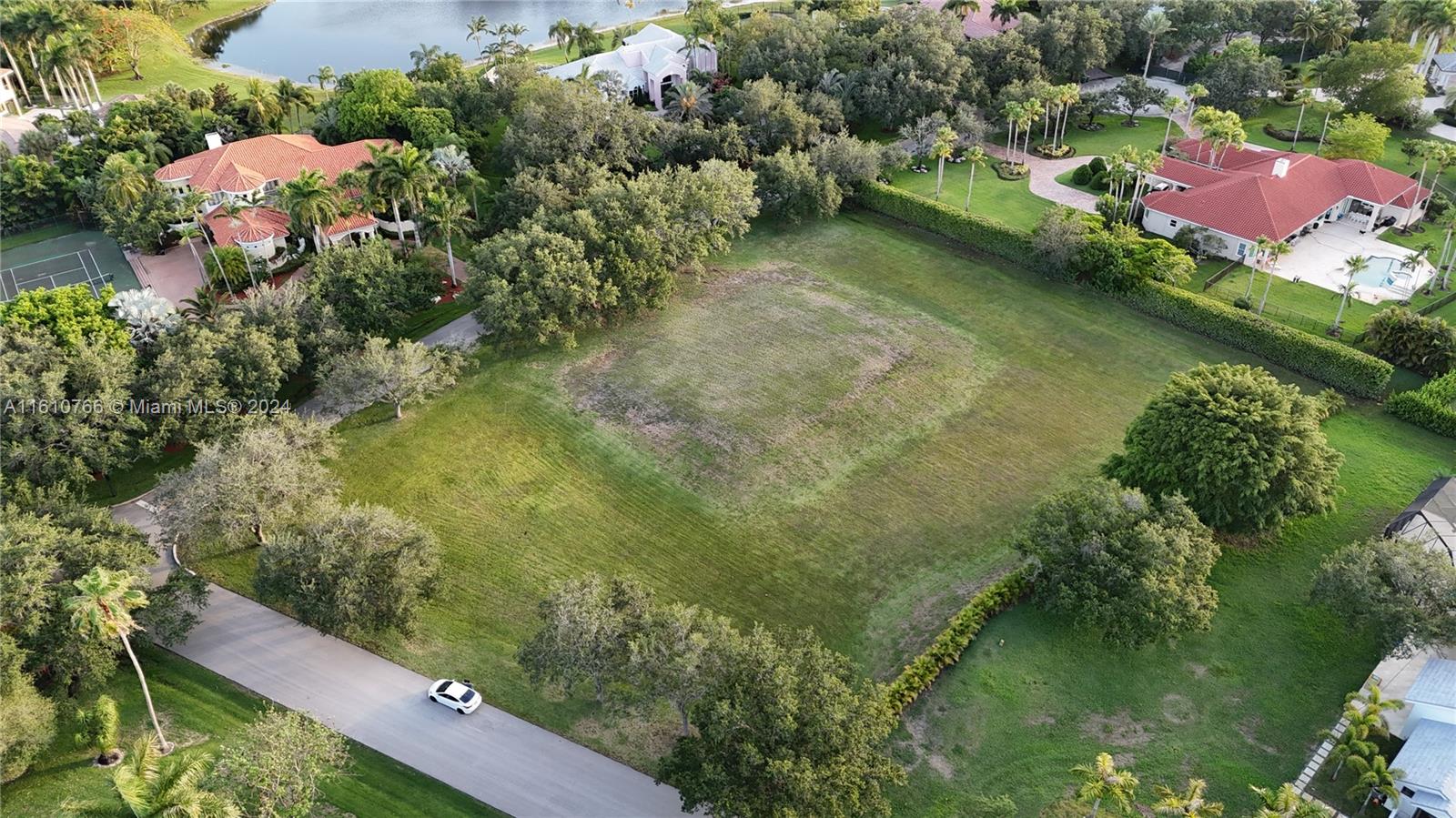 an aerial view of residential house with outdoor space and trees all around