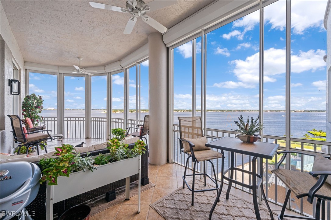 a dining room with furniture water view and a floor to ceiling window