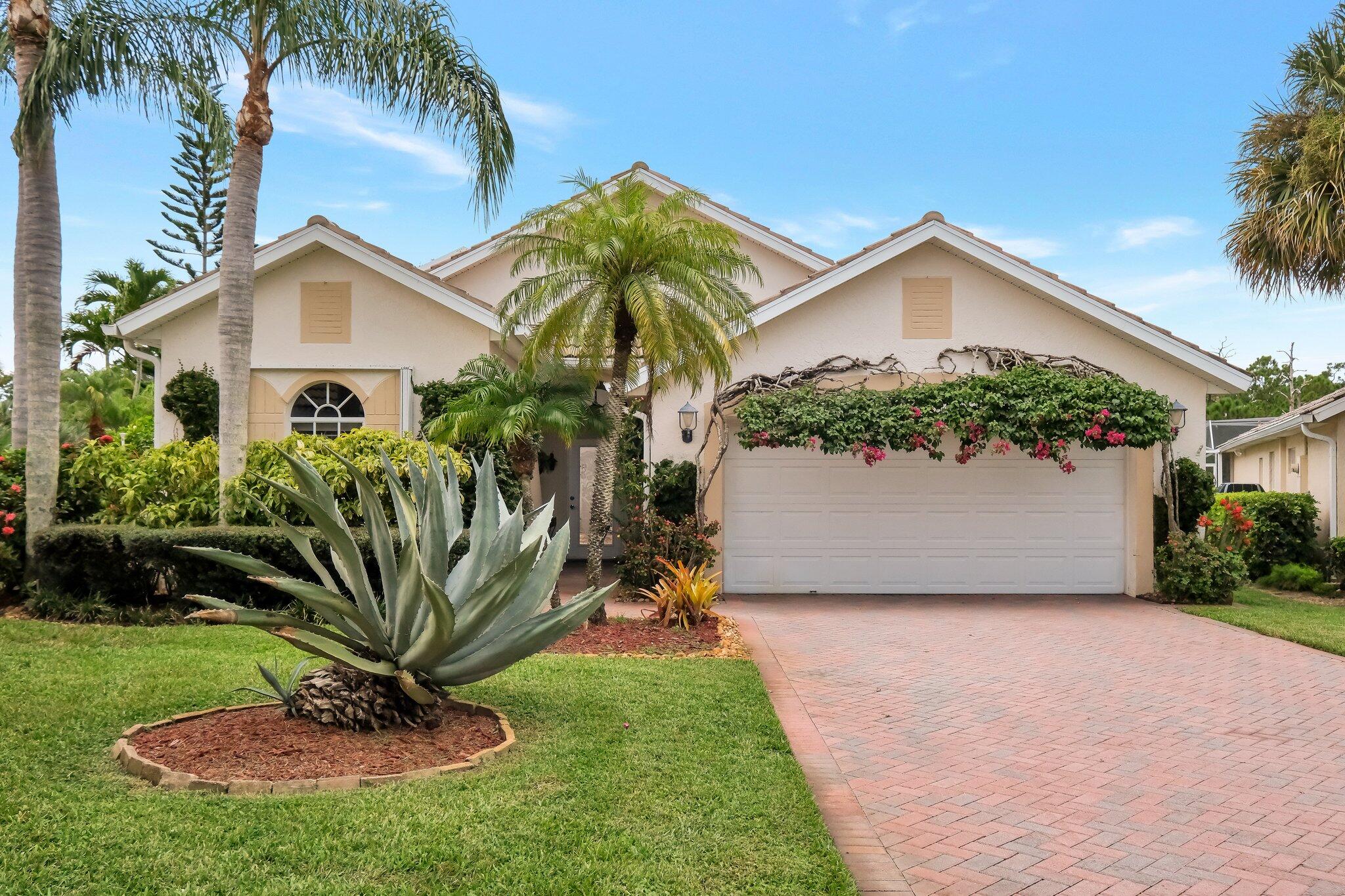 a view of a house with a yard and potted plants