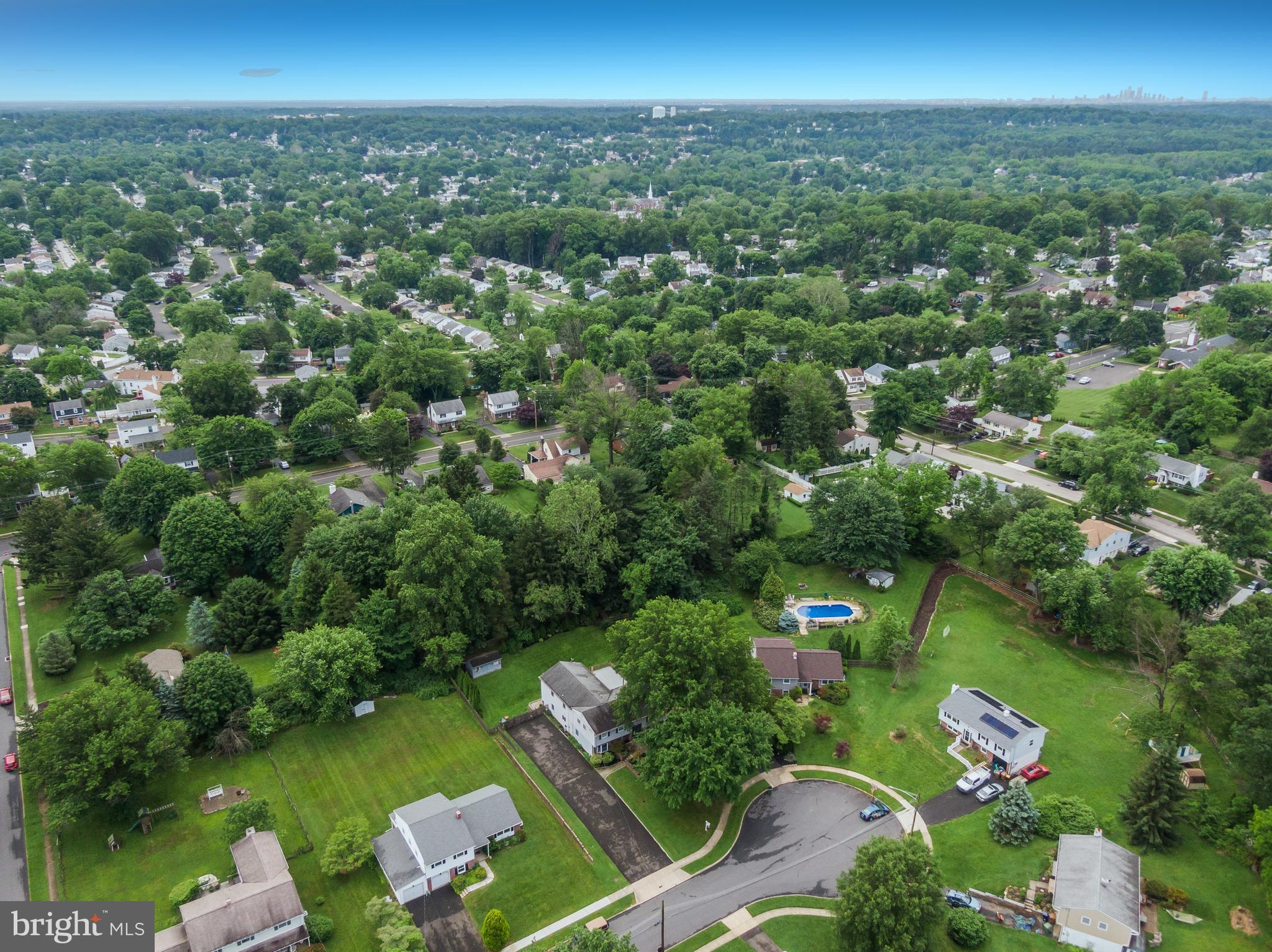 an aerial view of a city with lots of residential buildings and green landscape