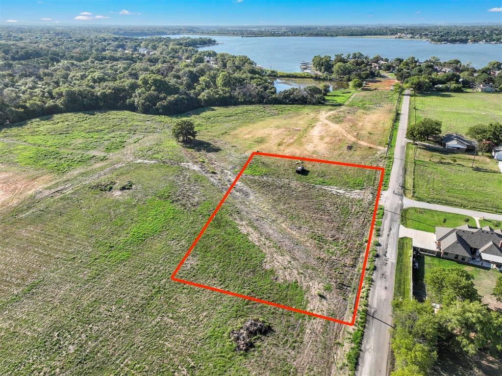 an aerial view of a house with a yard and lake view