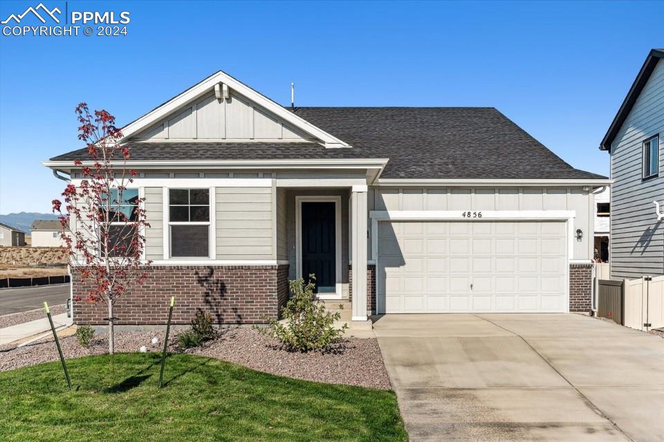 a front view of a house with a yard and garage