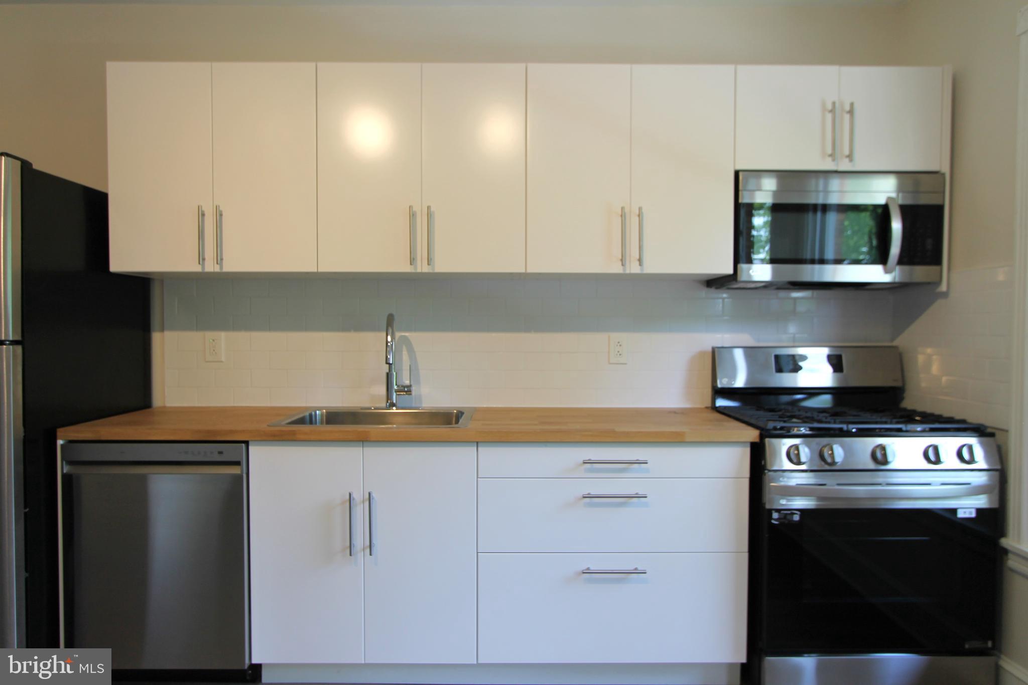 a kitchen with stainless steel appliances a sink a stove and microwave