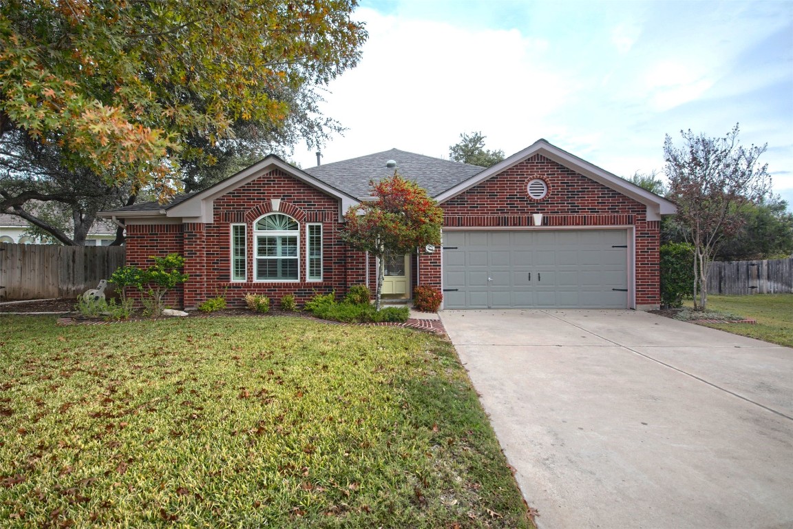 a front view of a house with a garden and trees