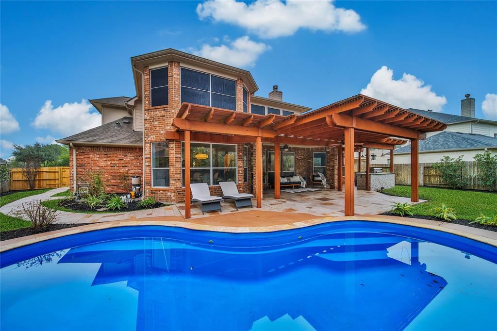 a view of a house with swimming pool and sitting area