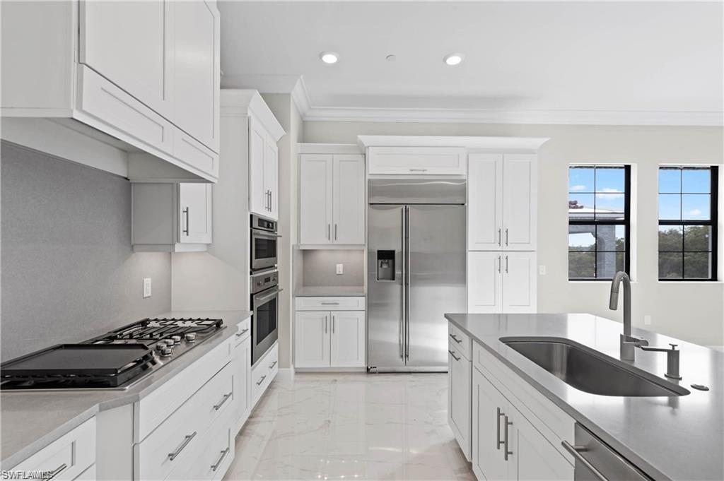 a kitchen with granite countertop a sink stainless steel appliances and cabinets