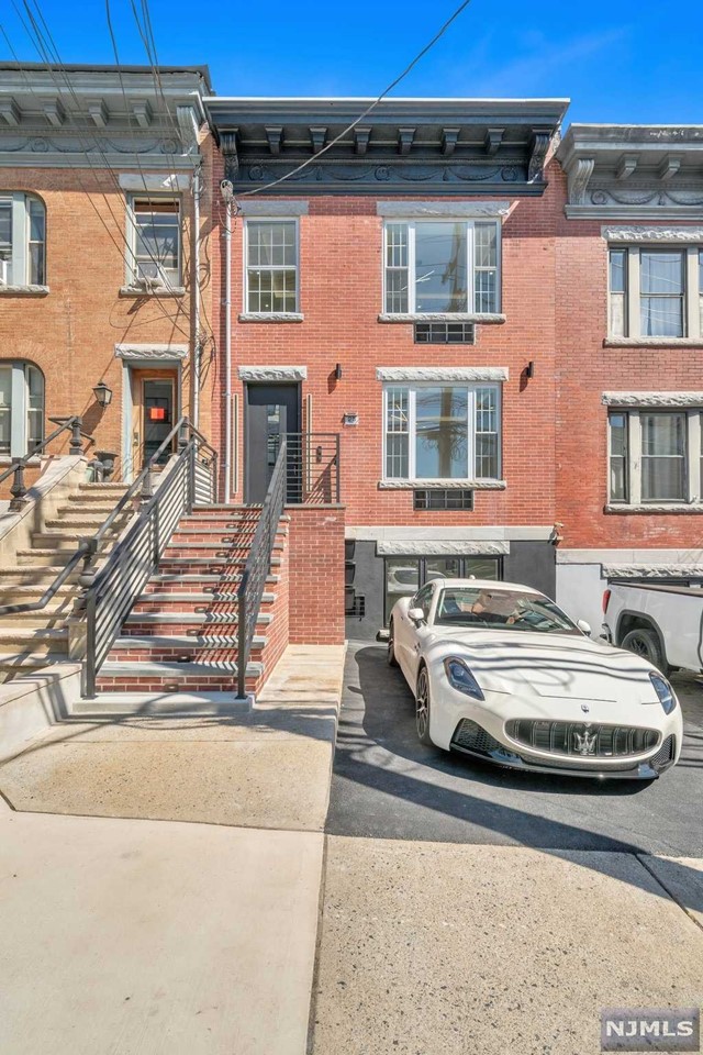 a front view of a house with cars parked